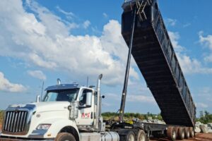 Muldenkipper mit angehobener Kippmulde auf einer Baustelle