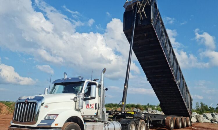 Muldenkipper mit angehobener Kippmulde auf einer Baustelle